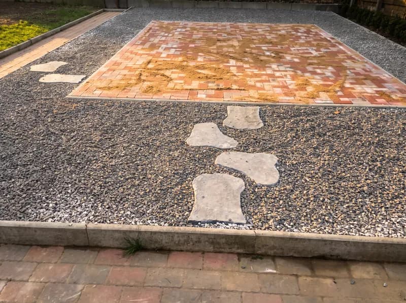 Gepflasterte Fläche mit Kiesbeet und Trittsteinen aus Naturstein – Pflasterarbeiten in Hohenlockstedt