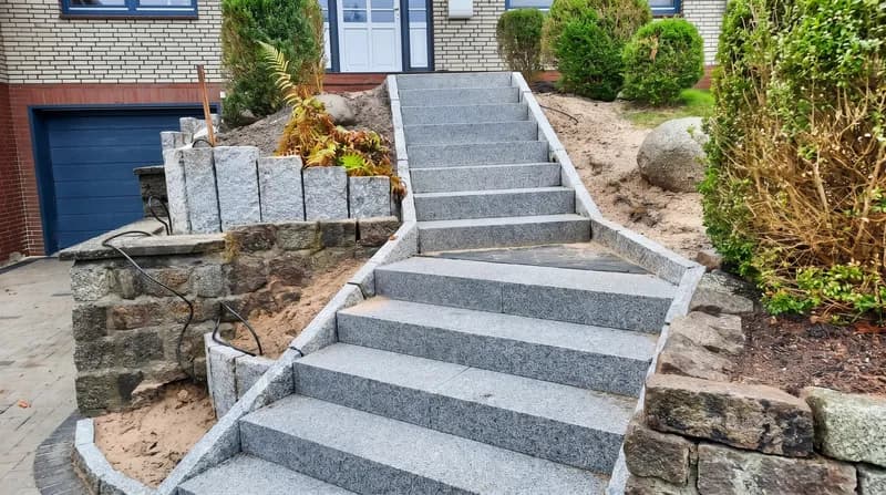 Granit-Blockstufen als Gartentreppe mit Natursteinmauer – Treppenbau vom GaLa-Bau Asmussen in Hohenlockstedt