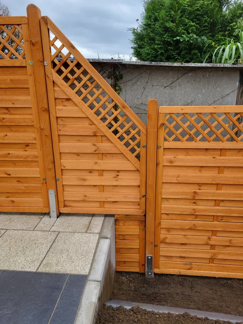 Holzzaun mit Rankgitter und Tür als Sichtschutz im Garten – Holz-Sichtschutz vom Garten- und Landschaftsbau Asmussen
